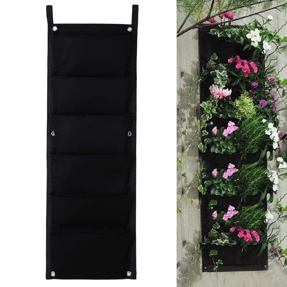 Vertical felt wall garden planter with multiple green planting pockets hung on a wooden fence