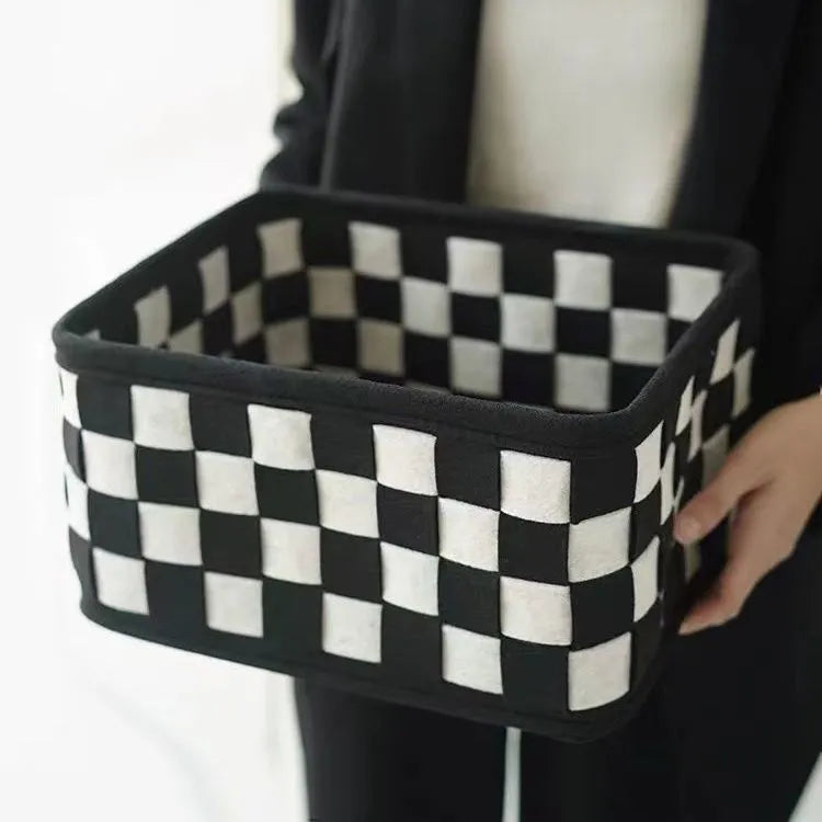 Black and white checkerboard patterned felt folding storage basket shown in its assembled box shape.