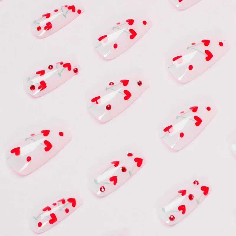Pack of 24 red French love themed nail art stickers with small cherry and diamond designs, includes glue.