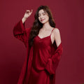 Red matching men's and women's ice silk sleepwear set with long sleeves and trousers.