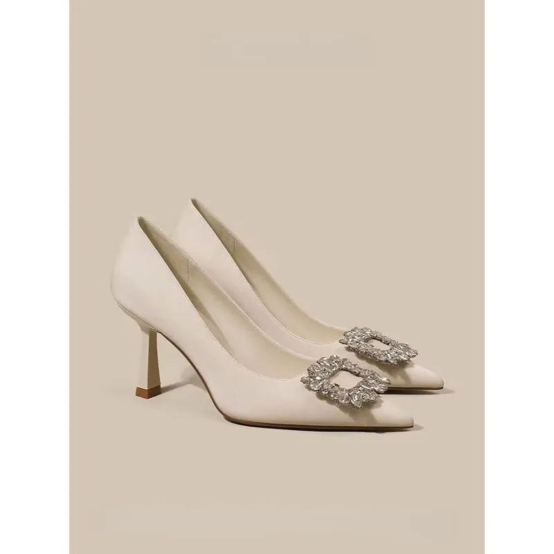 Women's pointed-toe stiletto heels in creamy white or black with a low-cut design and rubber sole.
