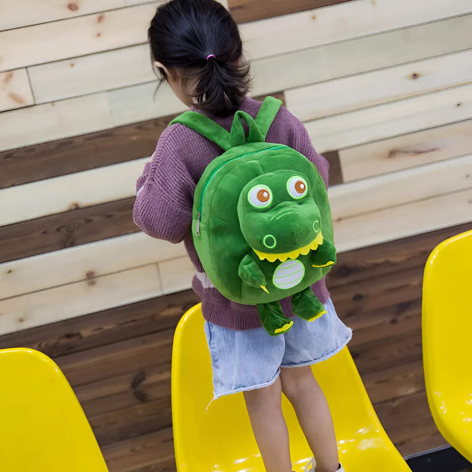 Soft blue dinosaur plush backpack for children with embroidery, shown with a soft handle and polyester lining.