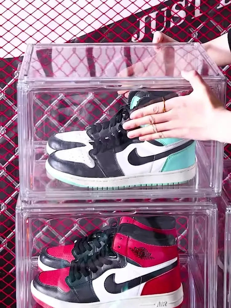 Large clear acrylic shoe storage box with a magnetic side door open, showing shoes inside.