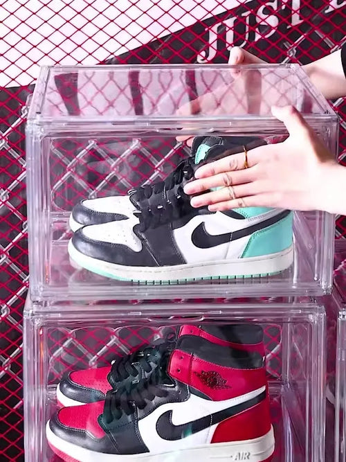 Large clear acrylic shoe storage box with a magnetic side door open, showing shoes inside.