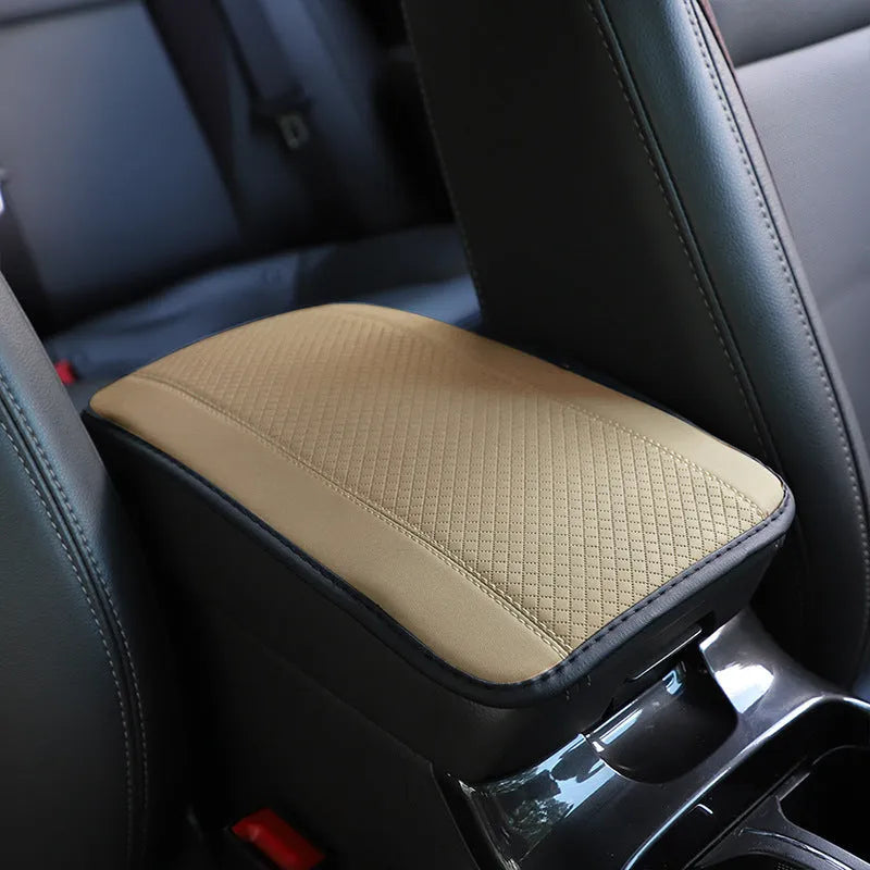 Embossed fibre leather car armrest box cushion measuring 32cm by 19cm in black with red trim