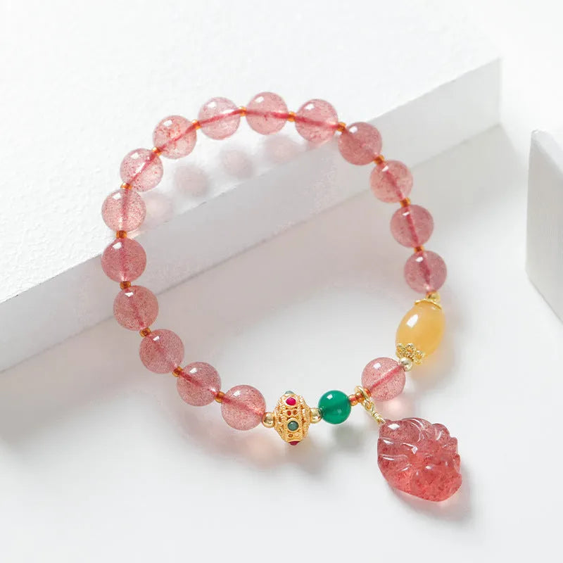 Women's Nine Tail Fox style strawberry quartz crystal beaded bracelet on wrist.