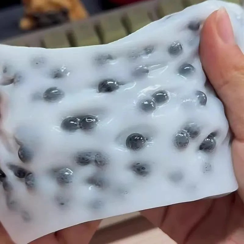 Black TPR decompression toy shaped like a tofu block on a plain background