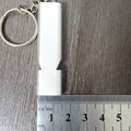 Gold and silver aluminium alloy double-hole survival whistle on a keyring.
