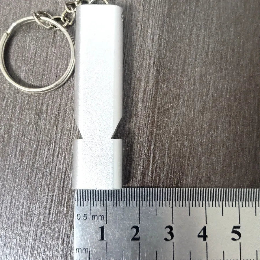 Gold and silver aluminium alloy double-hole survival whistle on a keyring.