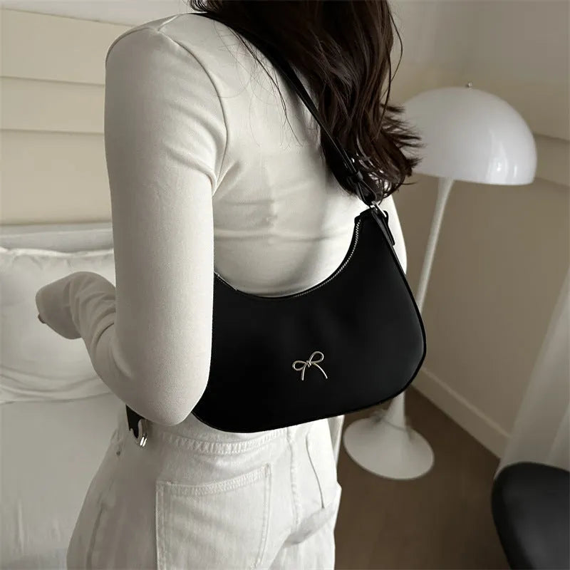 Small dumpling-shaped PU leather shoulder bag for women in multiple colours, showing the single strap and external pocket
