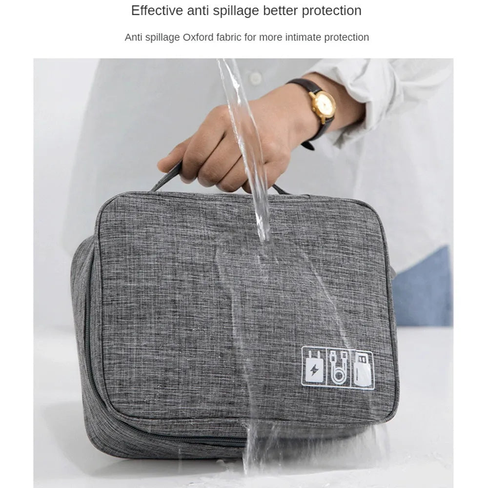 Black electronics organizer travel cable bag with removable dividers, mesh pockets, and a top handle