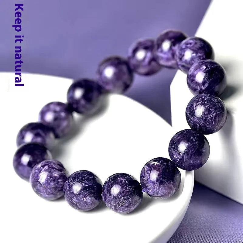 Natural purple charoite crystal bead bracelet on wrist with platinum plated silver clasp.