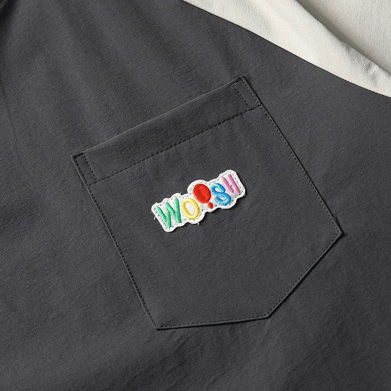 Dark grey loose fit T-shirt with contrast colour raglan sleeves on a hanger