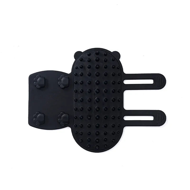 Black silicone cat grooming comb with rounded teeth and adjustable mounting strap for table legs.