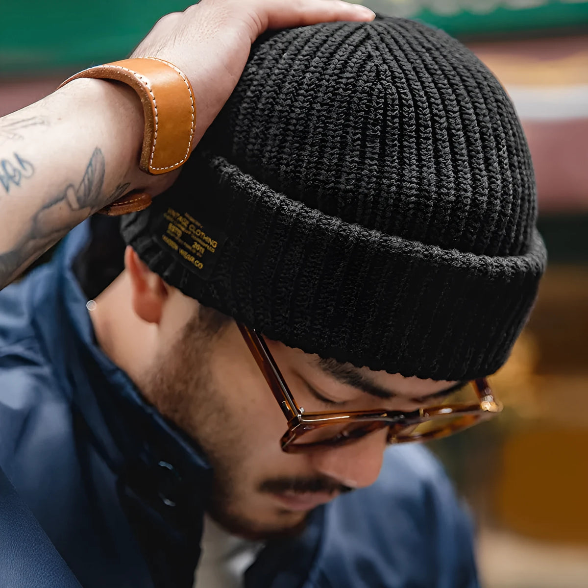 Vintage knitted melon skin warm beanie in black with patch detail on model wearing street-style outfit