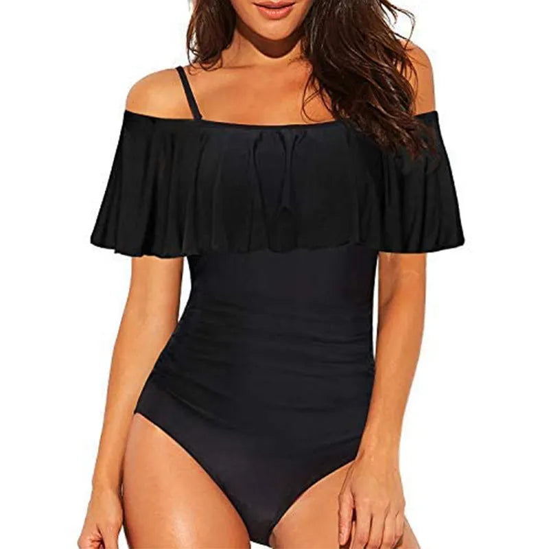 Black women's one-piece swimsuit with side cut-outs and ruffled straps on a tube top.