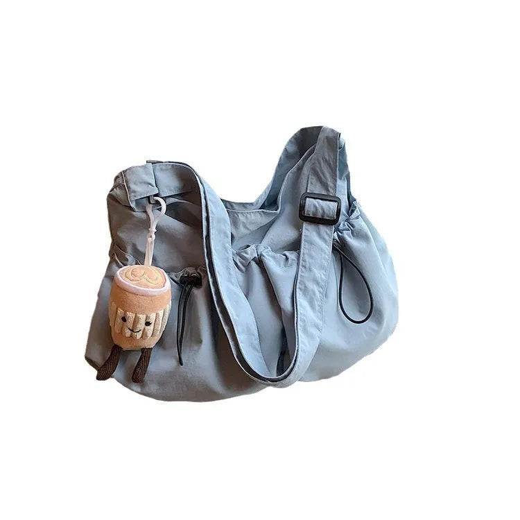 Ultra-light pleated crossbody bag in soft polyester fabric showing split pocket and phone compartment