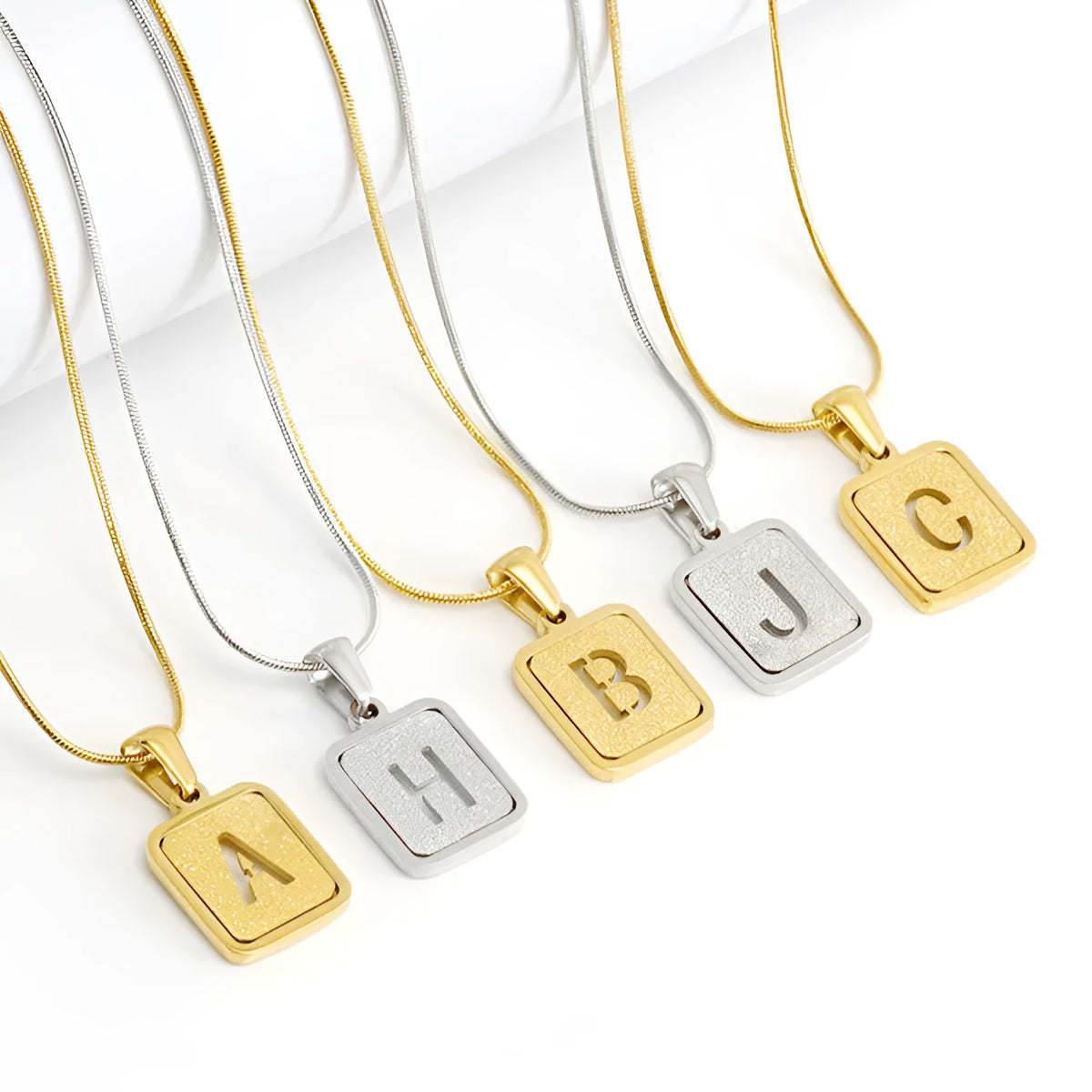 Alphabet necklace with square hollow-out letter pendant in titanium steel, gold or silver electroplated small snake chain