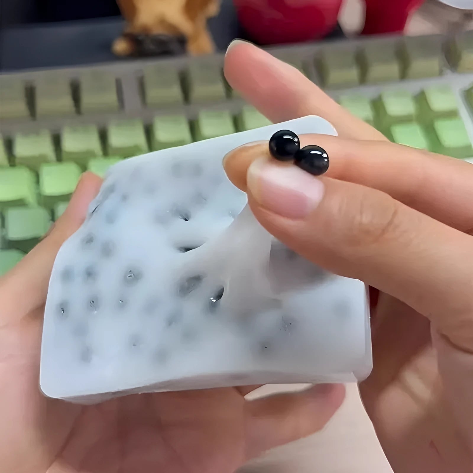 Black TPR decompression toy shaped like a tofu block on a plain background