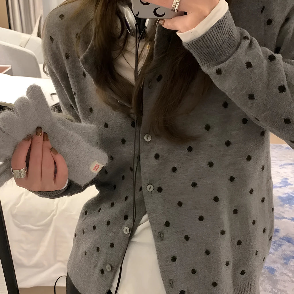 Women's grey dot pattern knitted cardigan with crochet floral detail on the front.