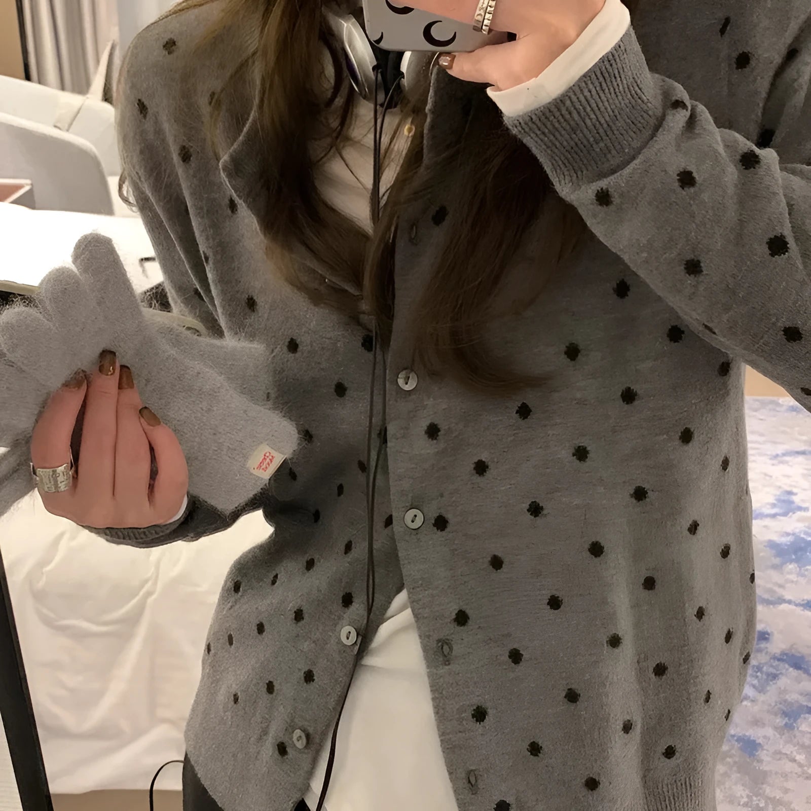Women's grey dot pattern knitted cardigan with crochet floral detail on the front.