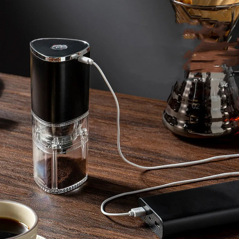 Portable white electric coffee grinder with USB charging cable and ground coffee