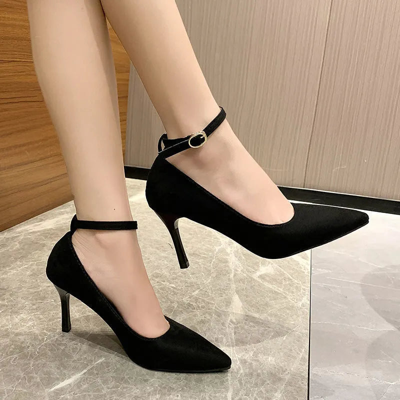 Women's black stiletto pump shoes with a silver buckle detail on the side.