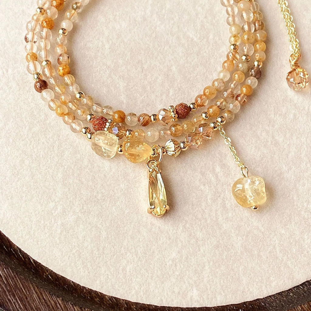 Women's three-circle citrine bracelet with caramel crystals and gold electroplated finish showing Saturn design detail