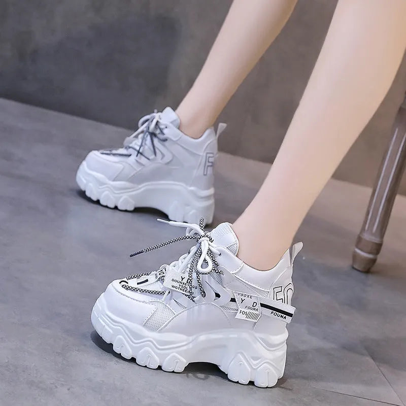 White women's low-top platform sports shoes with cross-strap and round toe on a rubber sole.