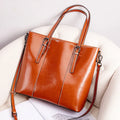 Brown genuine leather retro women's tote bag with multiple zipper pockets and three shoulder straps.