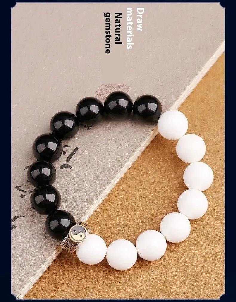 Black and white obsidian bracelet with Tai Chi symbol and mantra text on geometric beads.