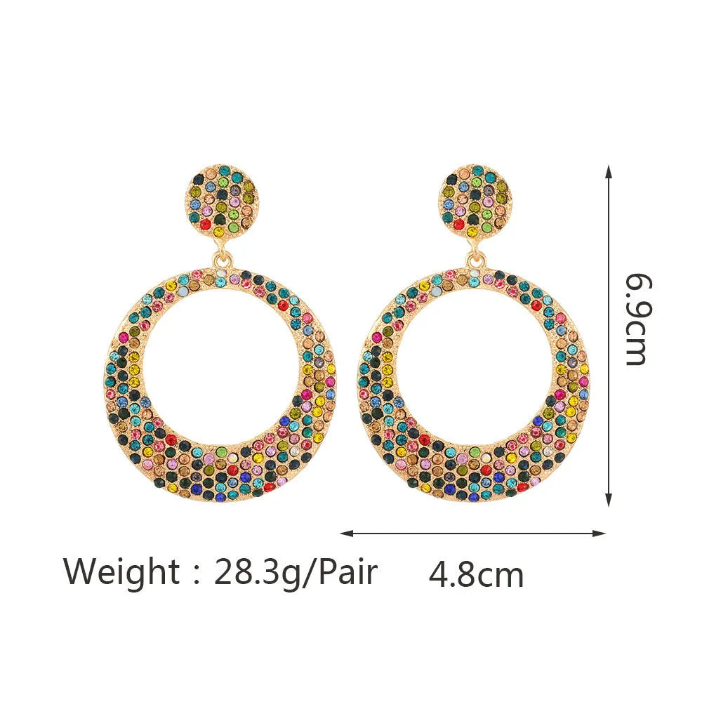 A pair of colourful metal alloy drop earrings with a large round pendant and diamond accents.
