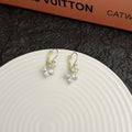 Platinum colour leaf-shaped earrings with inlaid zircon stones on white background