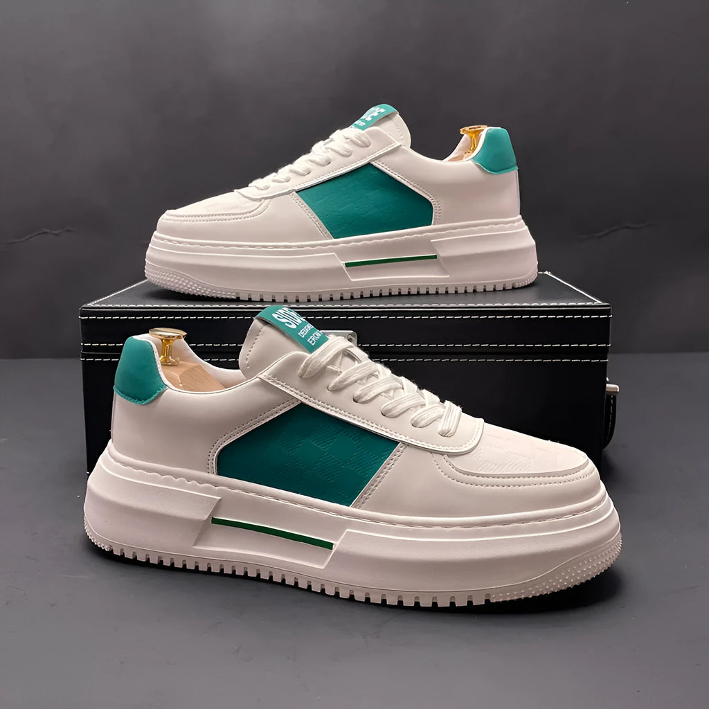 A pair of white, green, and black sports-style casual shoes with a cloth upper and rubber foam sole.