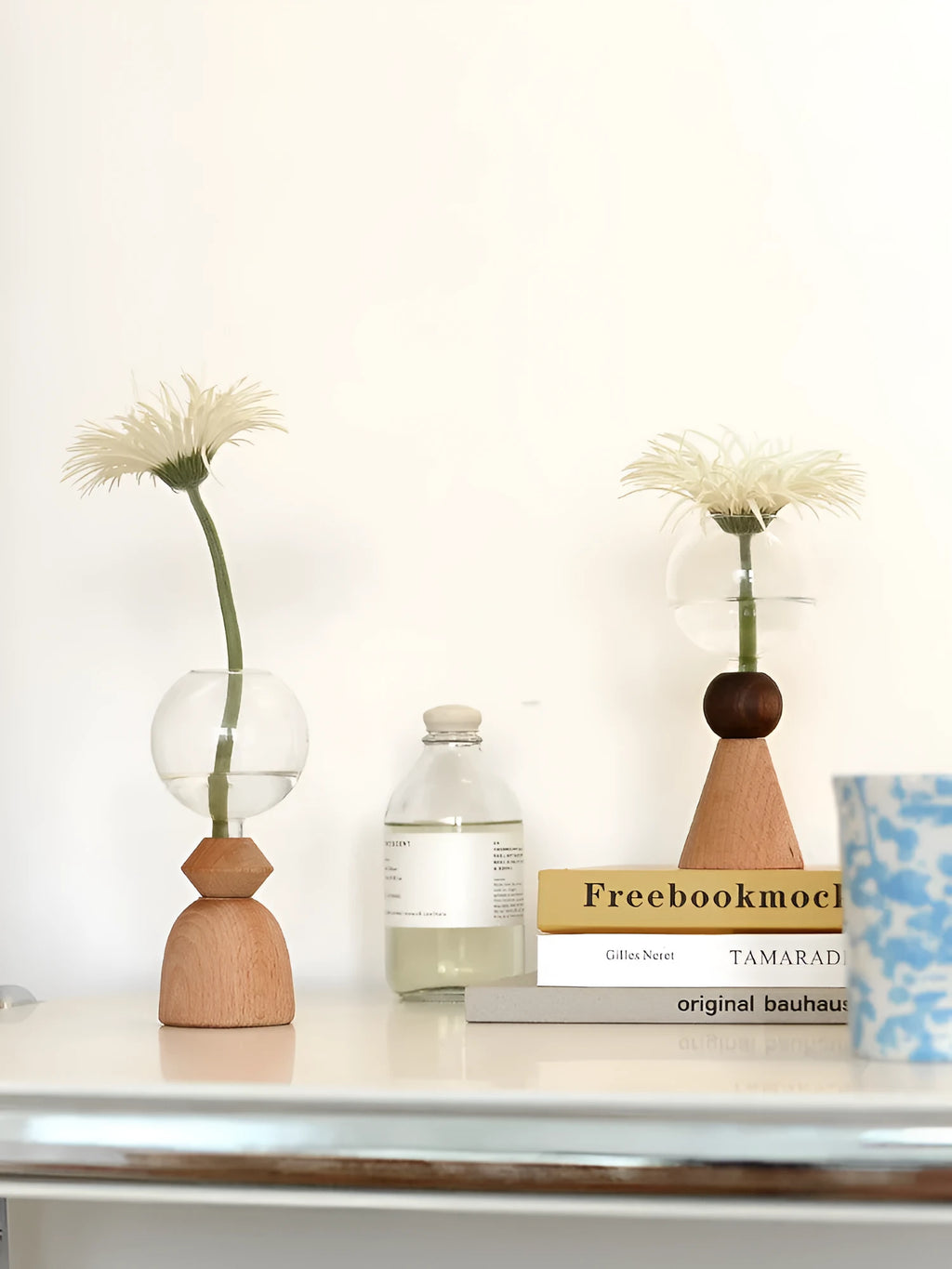 Small clear glass bubble vase on a wooden base, shown in conical bottom and arc bottom styles.