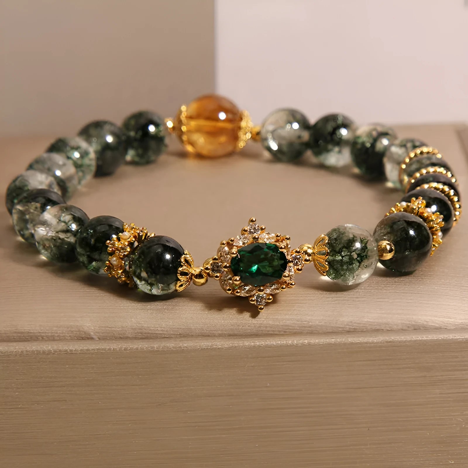 Women's gold rutilated quartz crystal bracelet with green phantom quartz accents, pearls, and rhinestones.