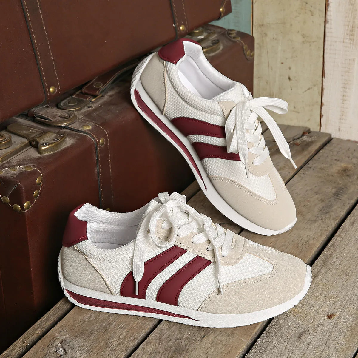 Wine red casual sneakers with cross straps over a breathable mesh and synthetic leather upper.