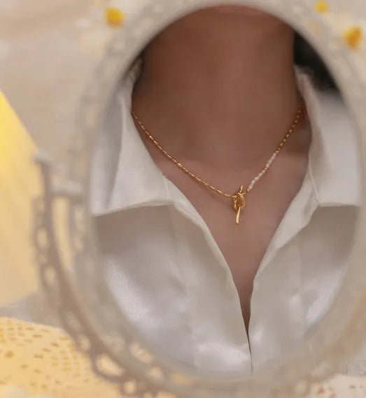 Gold electroplated natural real pearl necklace with copper geometric pendant and ring-line design on white background