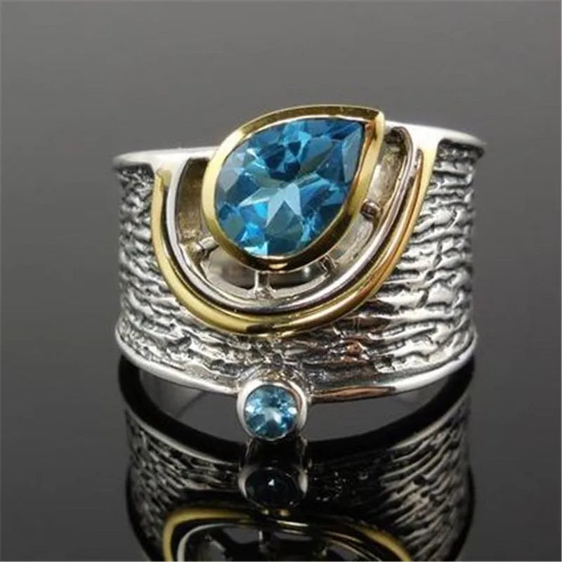 Blue drop-shaped women's alloy ring with inlaid zircon rhinestones on a finger.