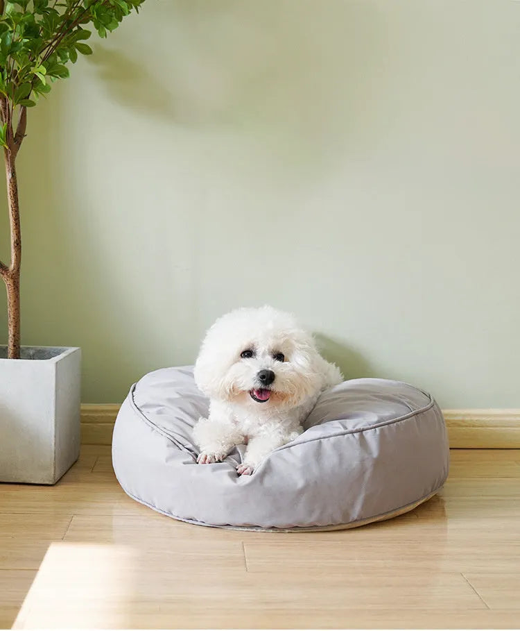 Fluffy pet bed in beige with raised rim on a light wood floor, available in sizes 60 to 80 cm diameter