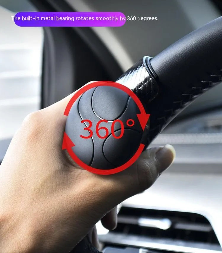 Black silicone steering wheel assistance ball with metal bearing booster installed on car steering wheel