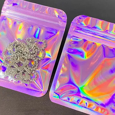 Laser internal printing ziplock bag in pink, 10x15cm size, with colourful internal print, lying flat on a surface