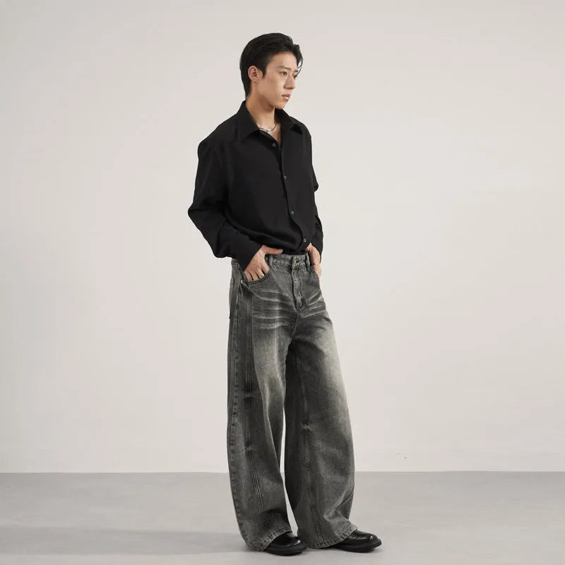 Men's loose straight washed denim jeans in black, front view showing zip fly and straight leg cut.