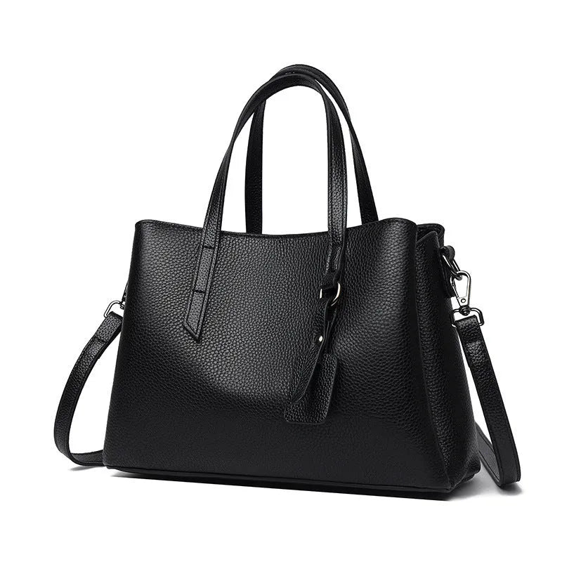 Women's cowhide leather shoulder handbag in horizontal square shape with tassel details and organised interior compartments