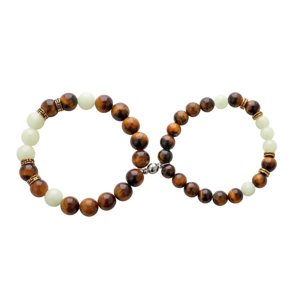 A pair of amber-coloured geometric resin bracelets with a luminous glow, shown together.