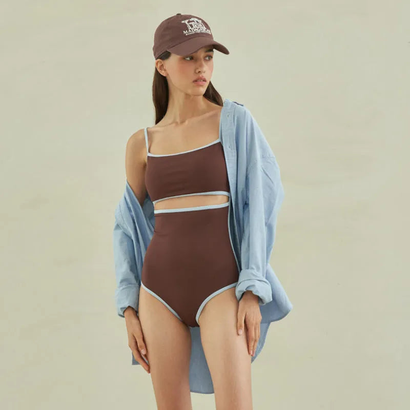 Brown triangle one-piece swimsuit for women on a mannequin, showing front design.