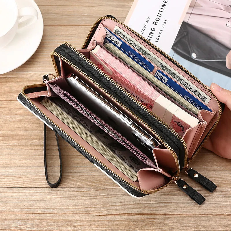 Black retro print long wallet clutch bag with zipper, holding a mobile phone and cards.