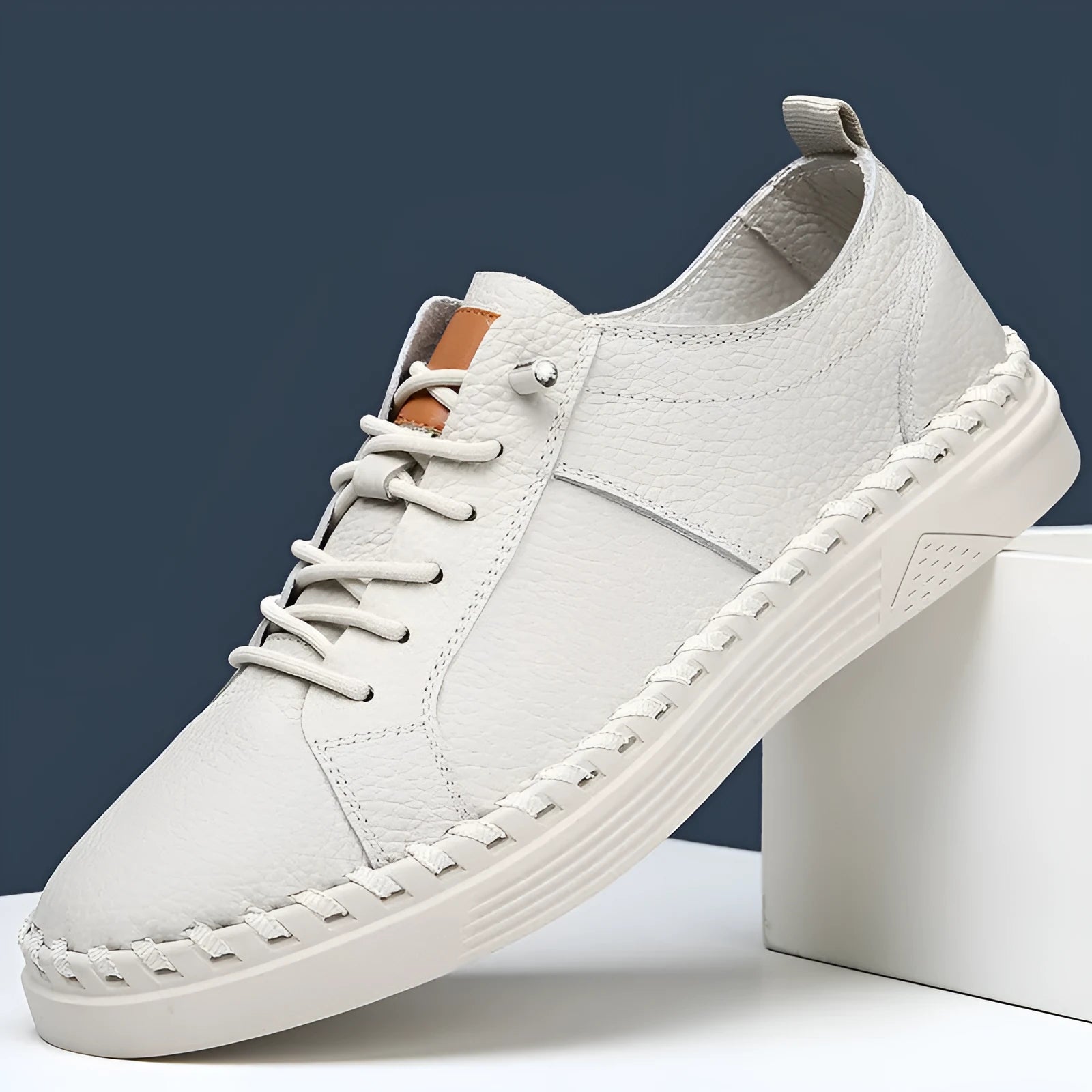 Men's beige casual leather sneakers with mesh lining and round toe stitching detail.