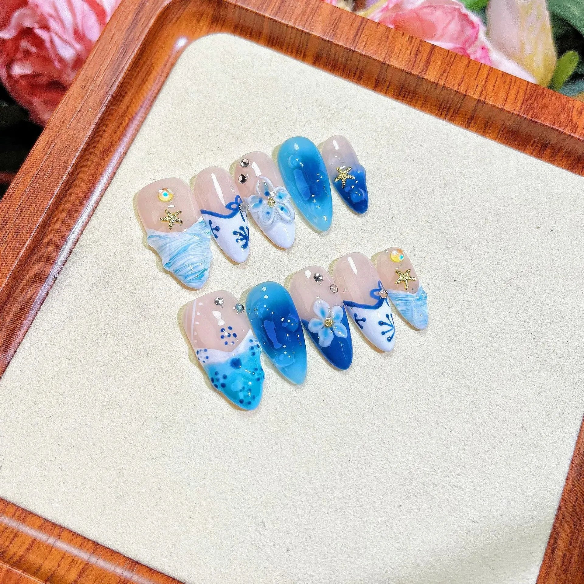 Blue hand-painted carved fake nails set with floral designs in sizes XS S M L