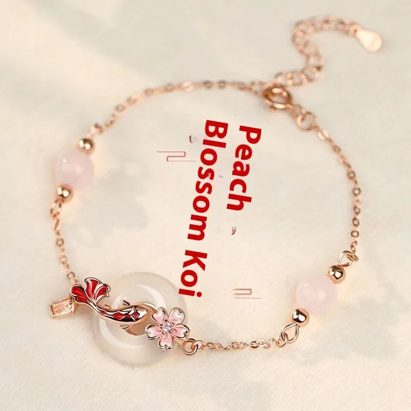 Women's sterling silver bracelet with Chinese floral design, white chalcedony crystal, and koi fish elements